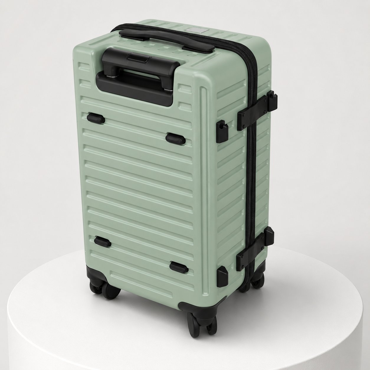 Back view of sage green ribbed suitcase with recessed carry handle and fold-out hook