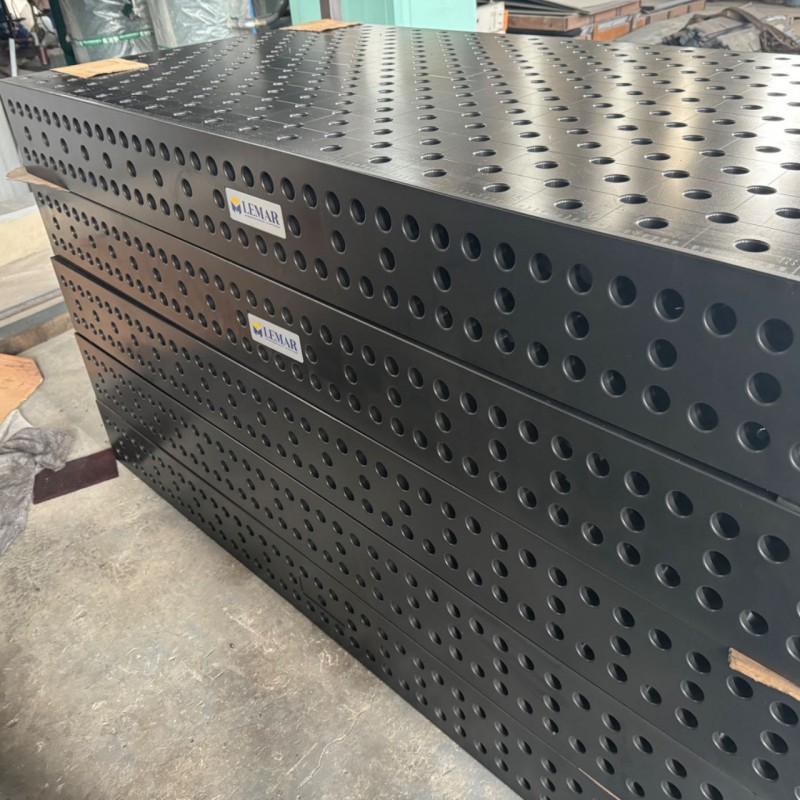 Close-up view of D28 welding table hole pattern and clamping accessories